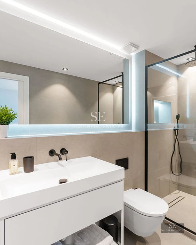 Spacious living room featuring panoramic windows, light wood floors, modern furniture, and minimalist decor. Breathtaking sea views.