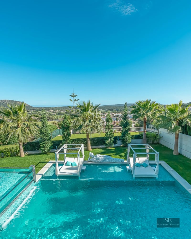 Spacious balcony overlooking the sea. Elegant outdoor furniture with armchairs and coffee table. Glass railing maximizes the panoramic view.