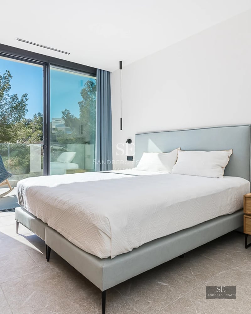 Grand balcon avec vue sur mer. Mobilier moderne, planchers en bois et rambarde en verre. Éclairage ambiant doux.