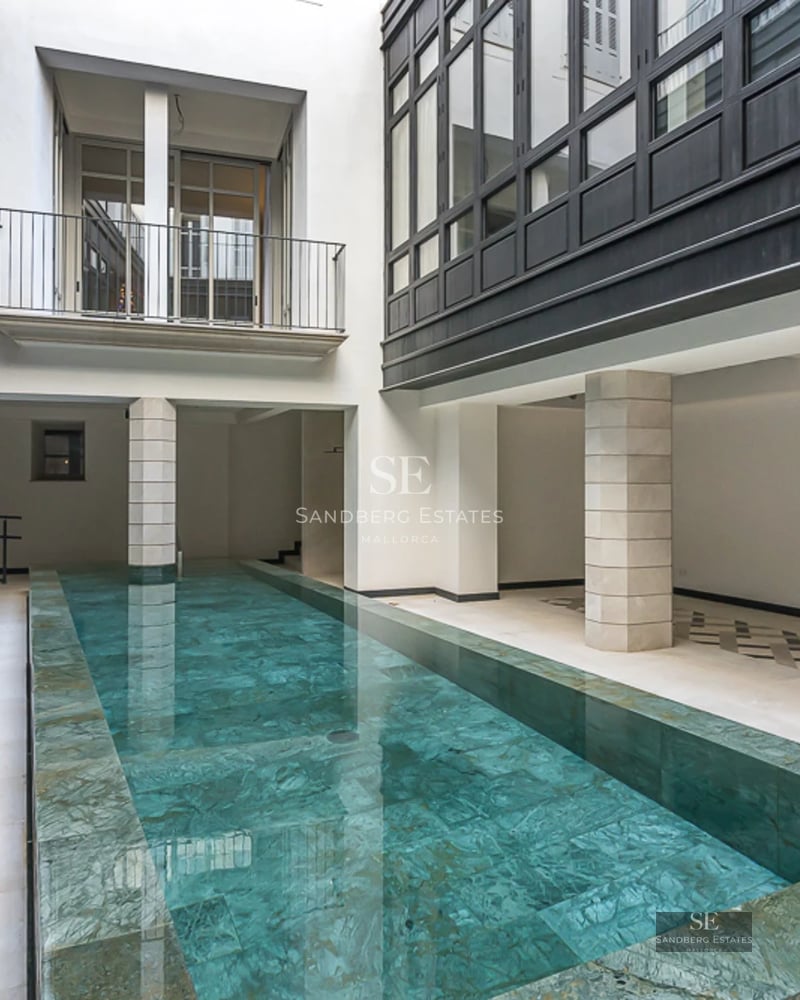 Spacious balcony with sea view, modern furniture, glass railing, wooden floor. Minimalist and elegant design.