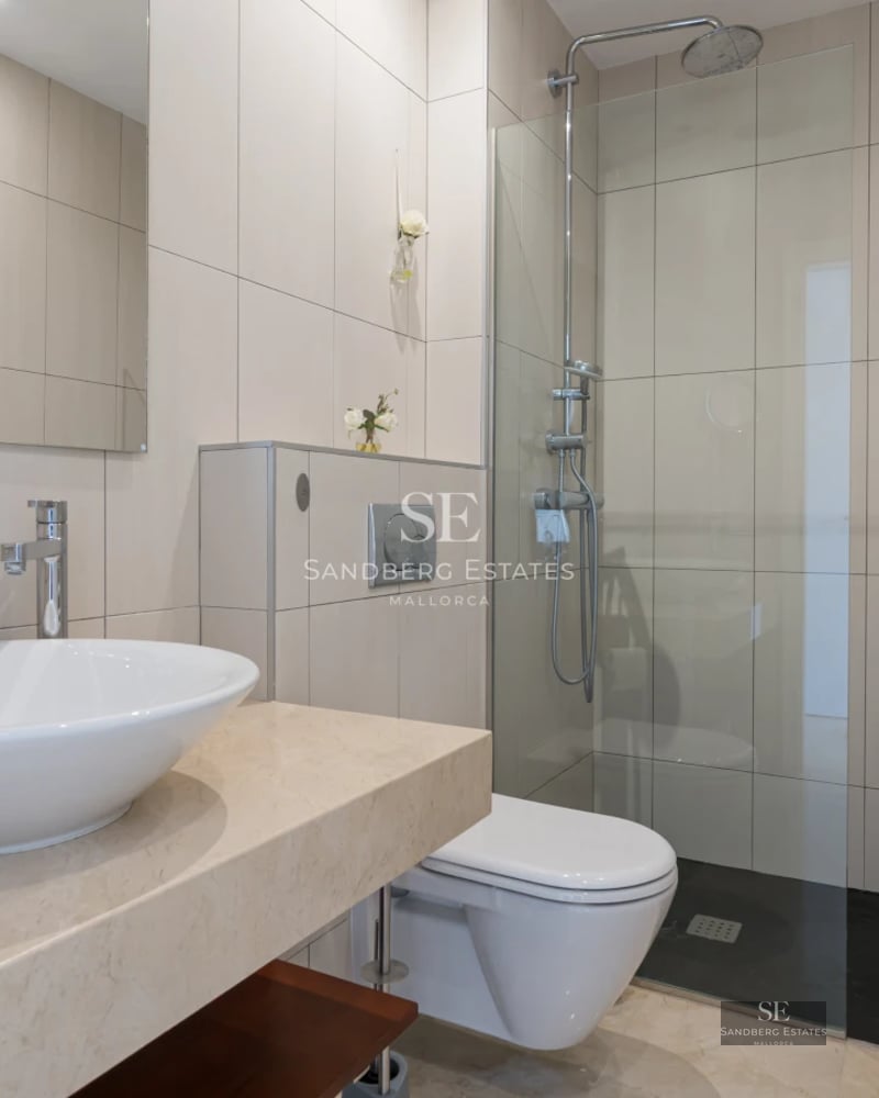 View of a modern villa with infinity pool. Minimalist architecture with large windows and terrace with sun loungers.