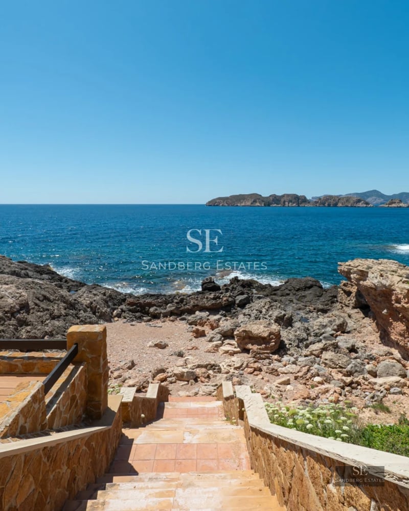 Spacious sea-view balcony, glass railing, modern furniture, wooden floor. Minimalist design with natural lighting.