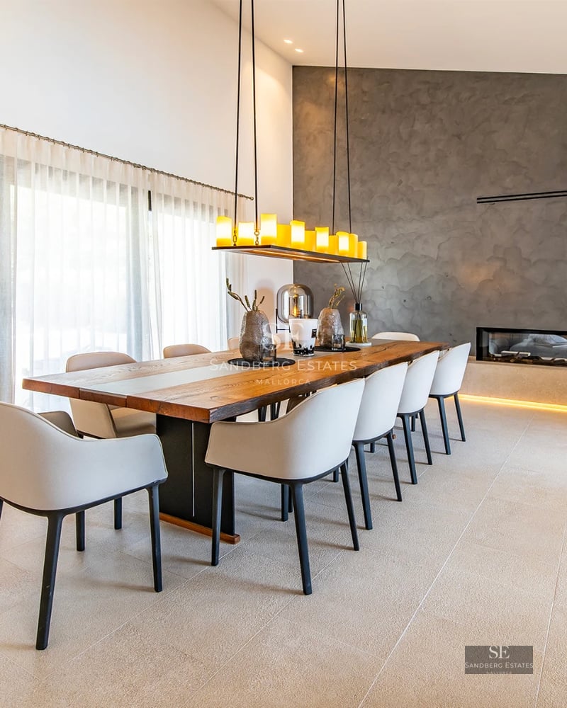 View of a modern villa with reflective pool. Minimalist design, large windows, lush natural surroundings and clear sky.