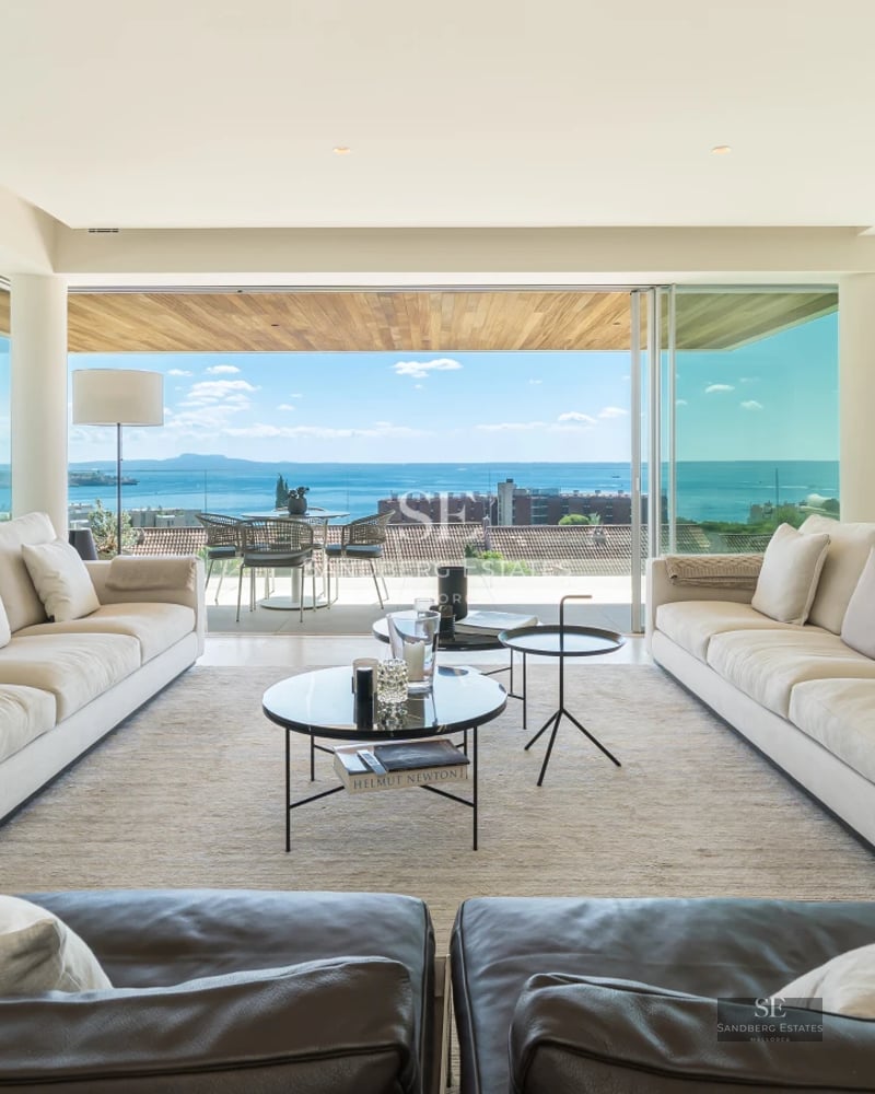 Exterior view of a modern villa with a pool, surrounded by greenery and featuring spacious outdoor living areas.