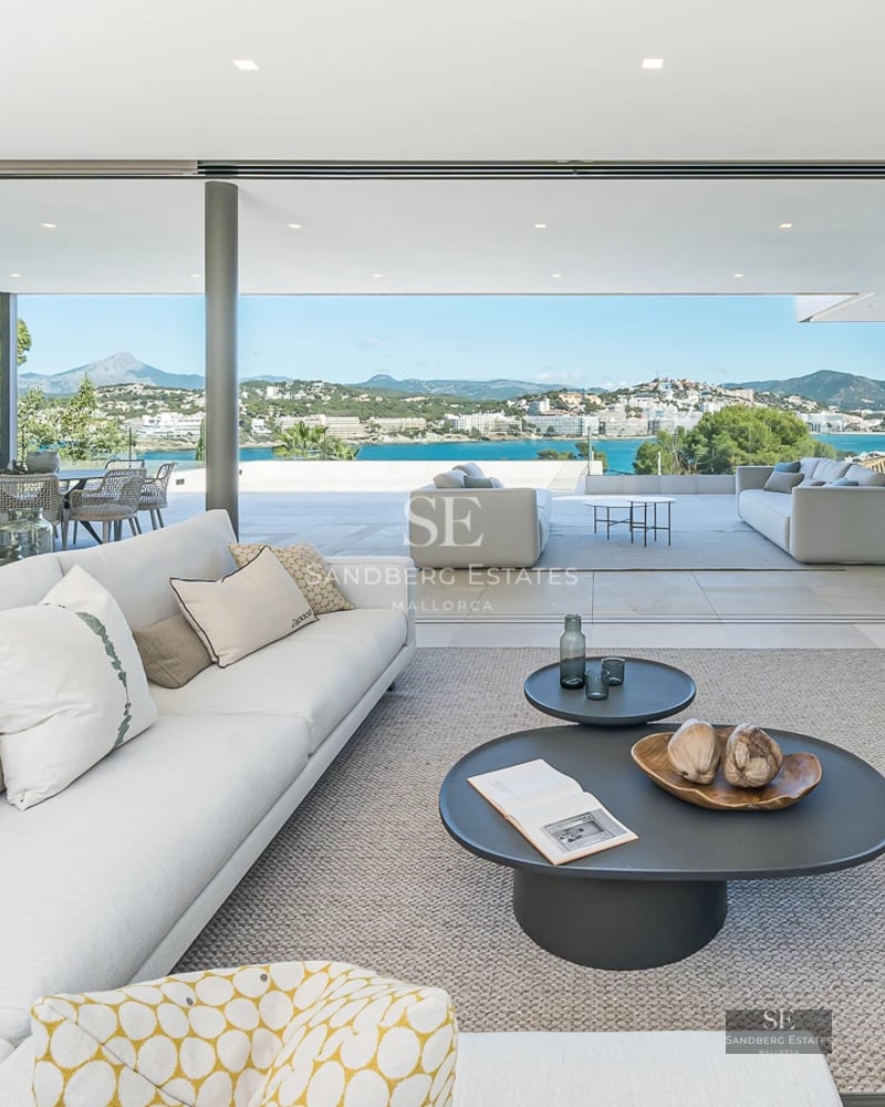 Exterior view of a modern villa with infinity pool, spacious terraces, and minimalist design. Ambient lighting and lush vegetation.
