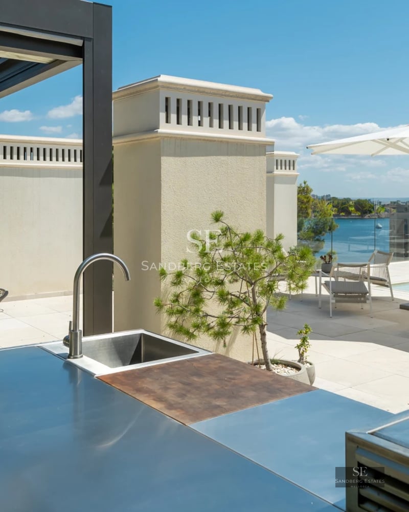 Exterior view of a modern villa featuring an infinity pool, lush garden, and contemporary architecture. Warm sunset lighting.
