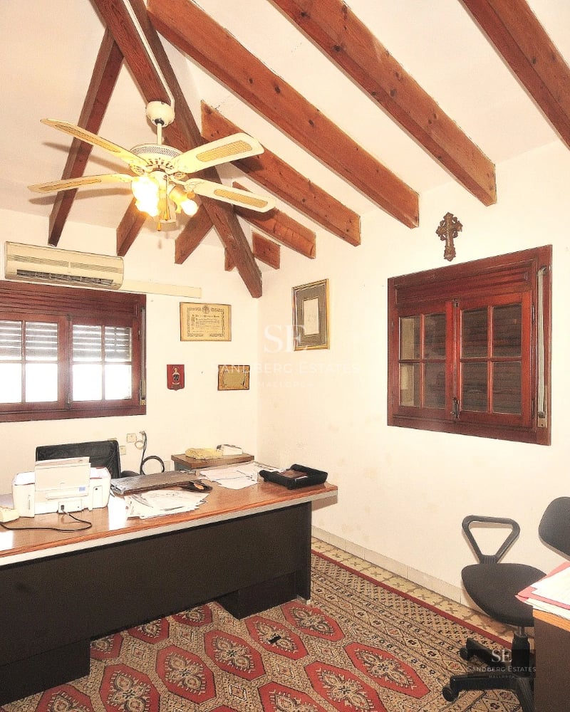 Spacious living room with window walls, beige sofas, fireplace and sea view. Elegant interior design with natural lighting.