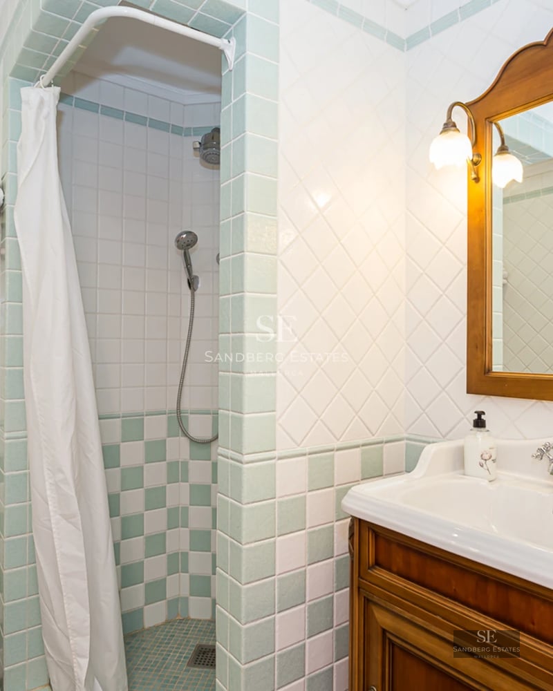 Grand salon avec baies vitrées, vue panoramique sur la mer, parquet clair et mobilier moderne. Lumière naturelle abondante.