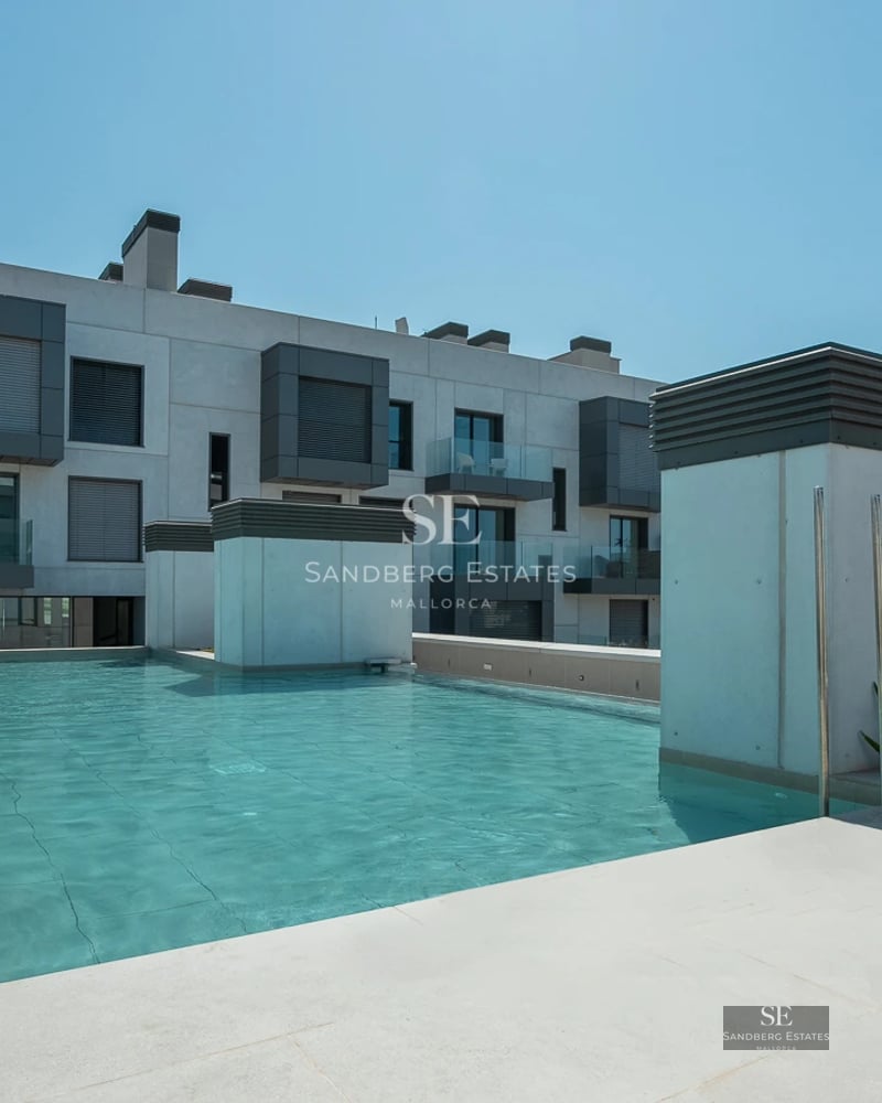 Spacious living room with large windows, light wood flooring, and panoramic sea views. Modern sofa and minimalist decor.