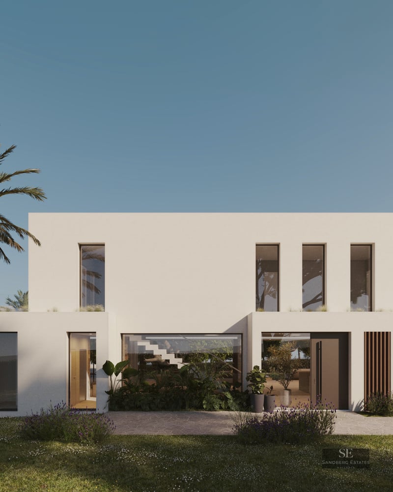 Modern white two-story villa with large glass windows and lush garden featuring a palm tree.