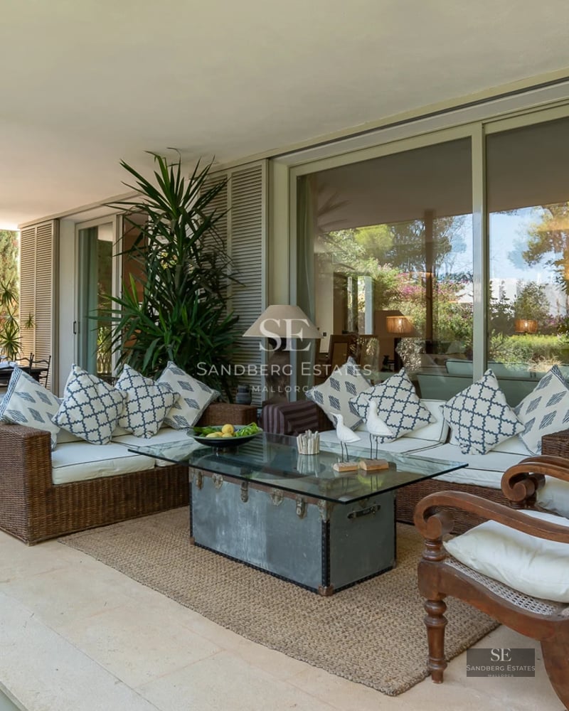 Spacious balcony with sea view. Modern outdoor furniture, glass railing and tiled floor. Luxurious and bright space.