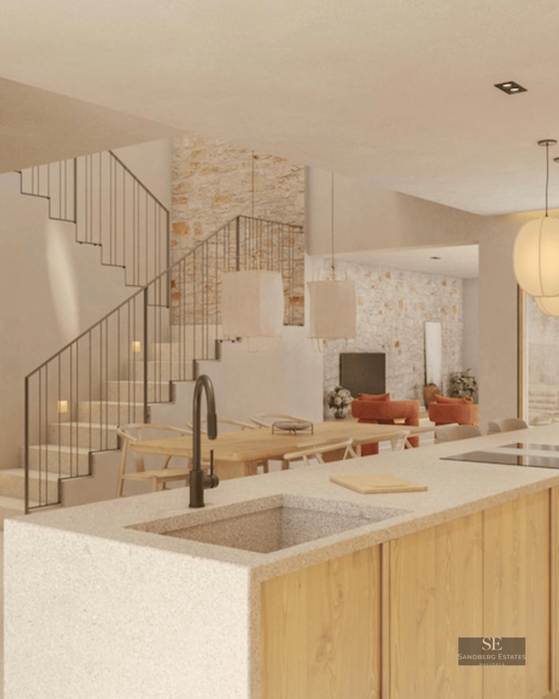 Modern kitchen island with stone sink and wood finishes, integrated with dining area and staircase.
