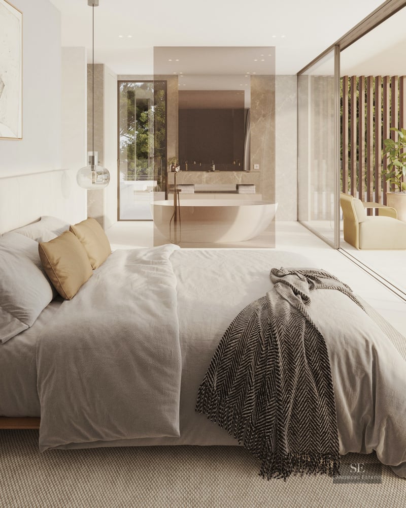 Modern bedroom with a large bed, glass walls showing a terrace, and an open-plan bathroom with a freestanding tub.