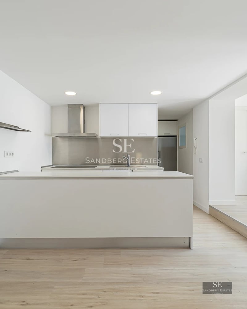 Wide view of modern living room with fireplace, balcony, and panoramic windows. Natural light, elegant design, neutral colors, and luxurious textures.