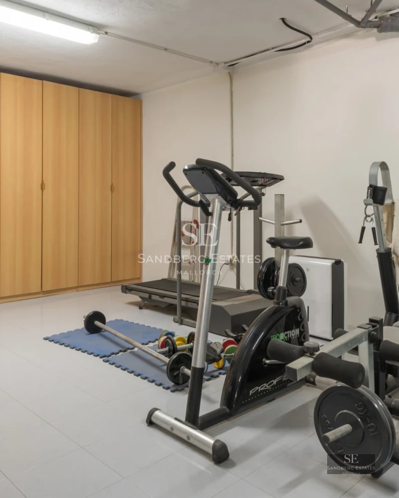 Exterior view of a modern villa featuring a pool, sun loungers, and a large garden. Contemporary architecture with expansive windows.