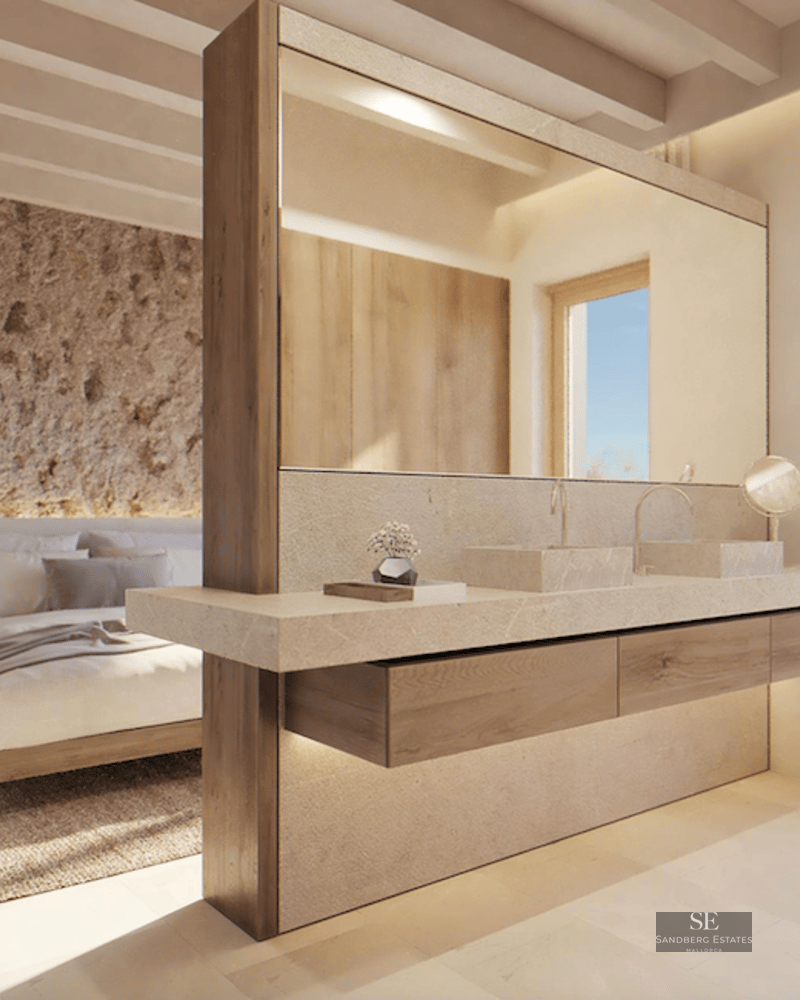 Modern master bedroom with integrated stone double vanity, rustic stone accent wall, and timber-beamed ceiling.
