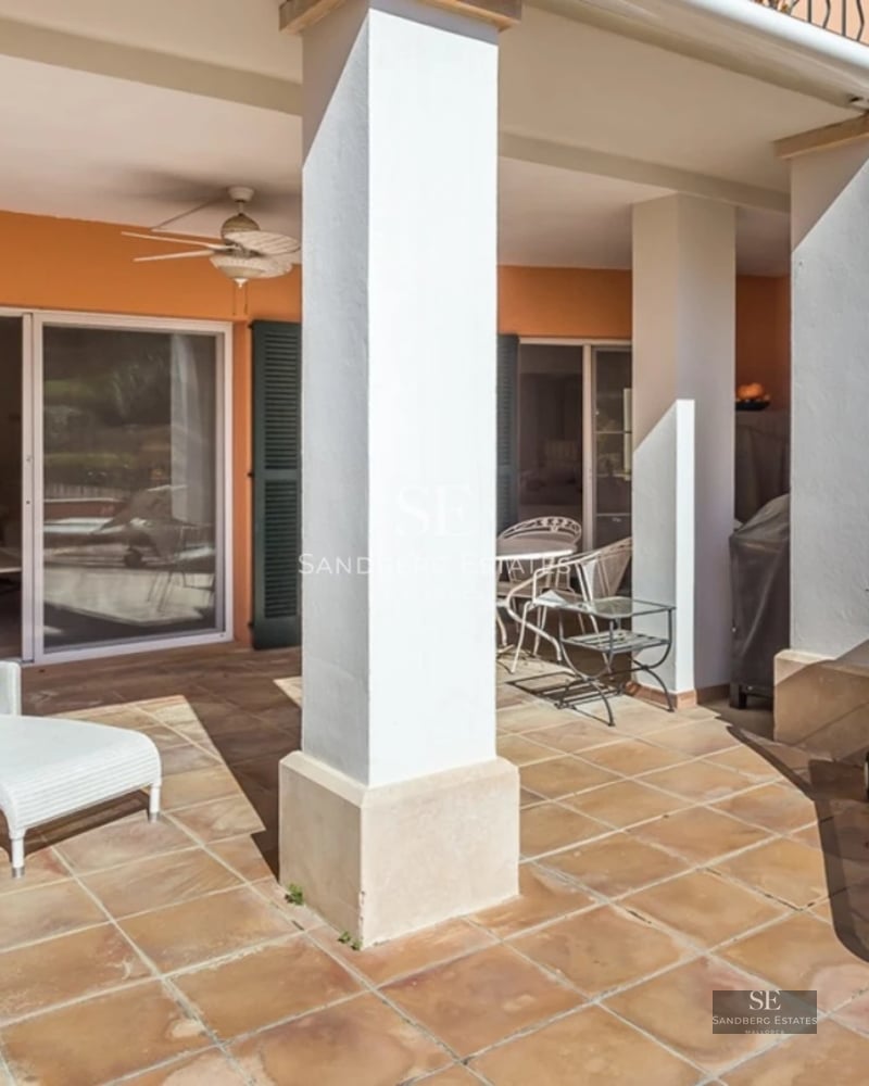 Exterior view of modern villa with swimming pool, minimalist architecture, large windows, manicured garden and clear sky.