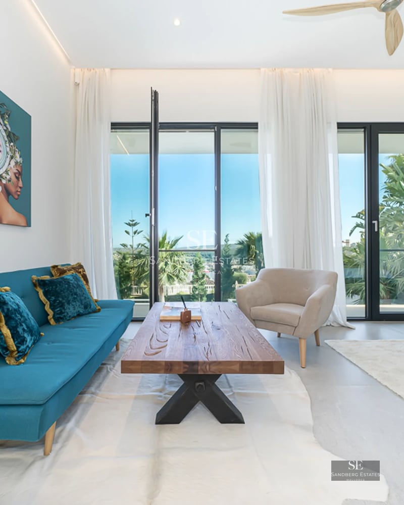 Exterior view of modern villa featuring an infinity pool, expansive terraces, and minimalist architectural design. Soft ambient lighting.