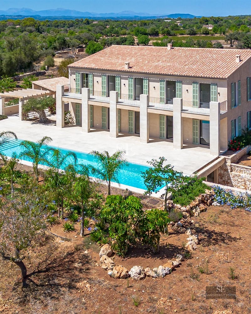 Spacious living room with large windows overlooking an infinity pool. Modern and elegant design with abundant natural light.