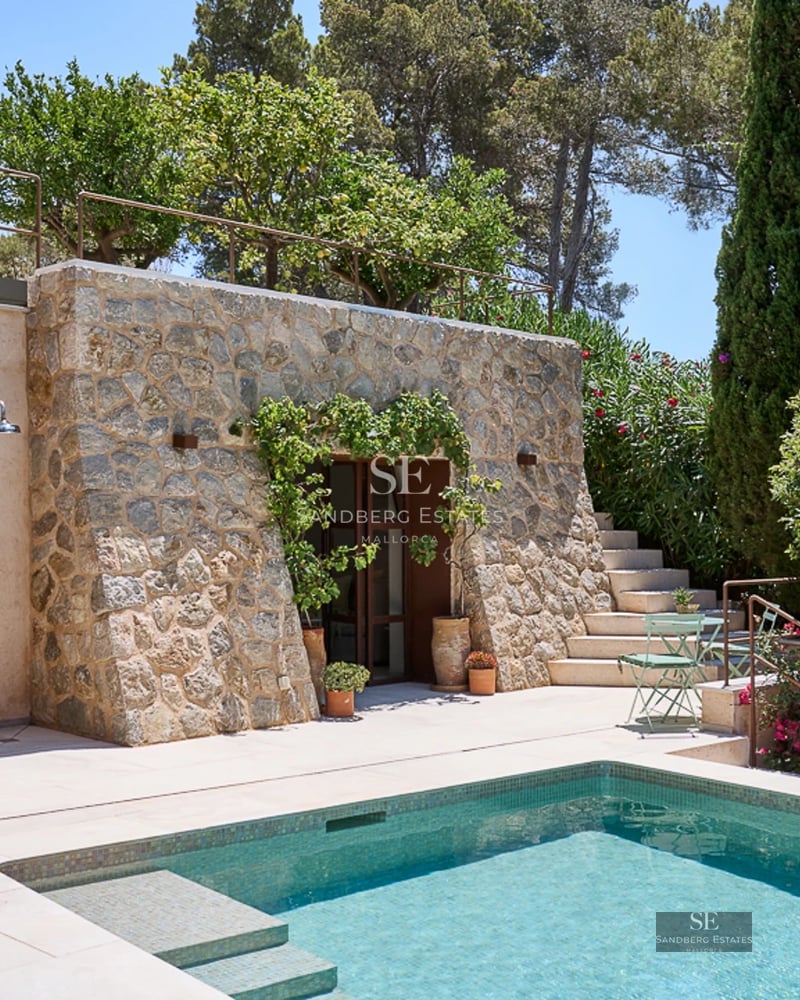 Spacious living room with floor-to-ceiling windows, natural light, light wood floors, and modern designer furniture. Elegant and comfortable.