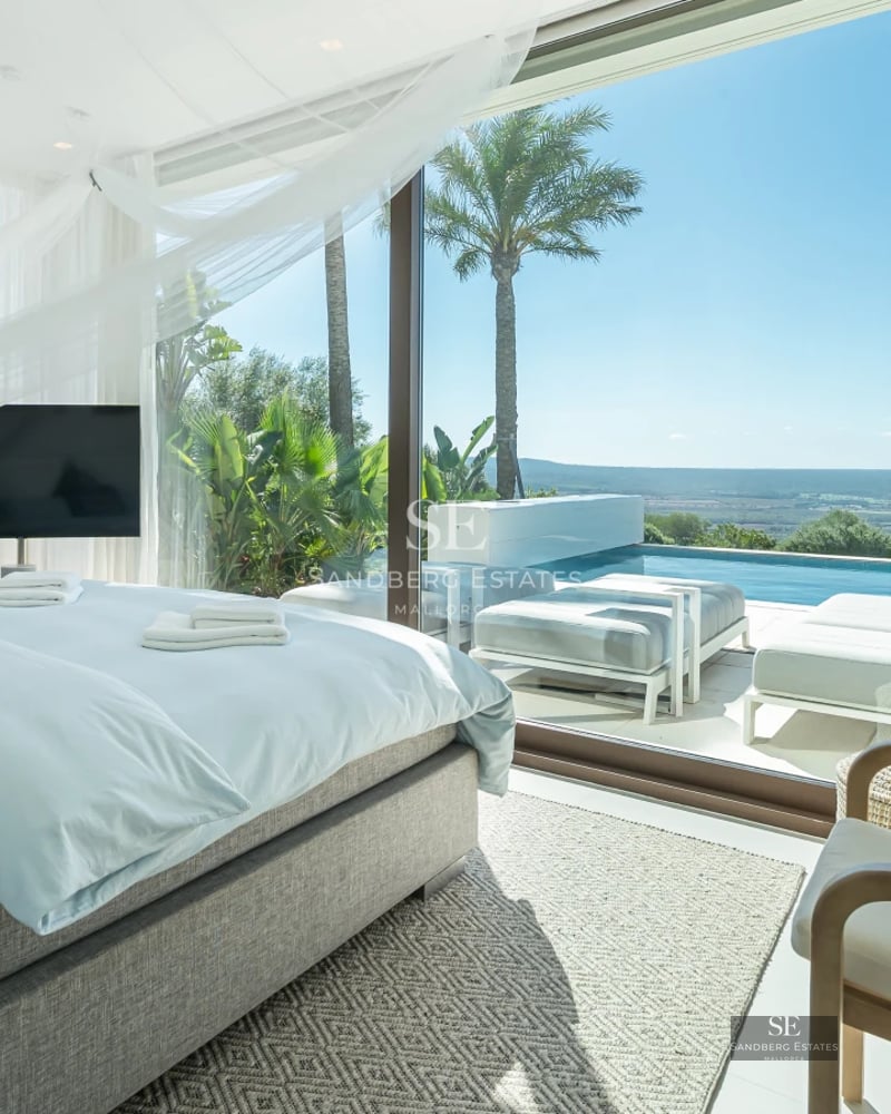 Spacious living room with panoramic windows, modern fireplace, and minimalist design. Spectacular sea views.