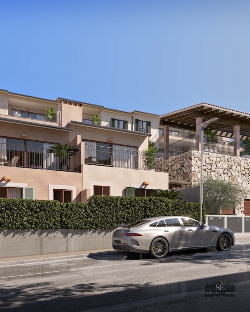 Multi-story Mediterranean villa with natural stone walls, balconies, green shutters, and a silver sports car.
