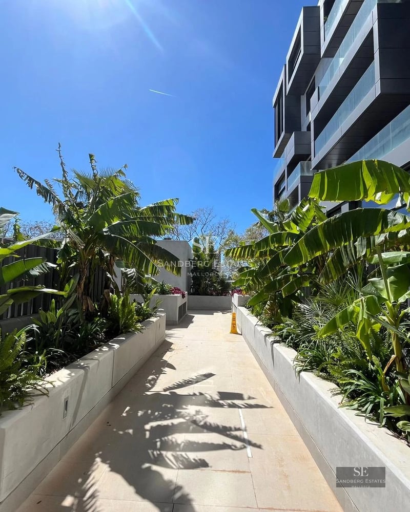 Exterior view of a modern villa featuring an infinity pool, lush garden, and expansive terraces. Minimalist and elegant architectural design.