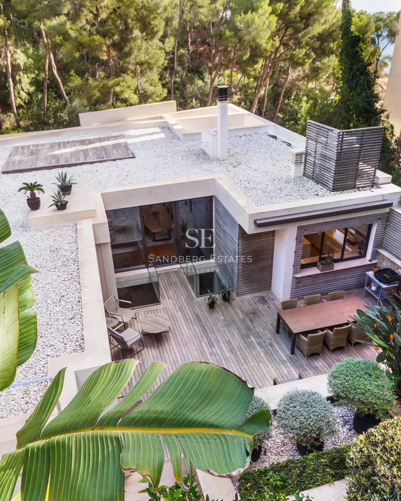 Modern facade with reflecting pool. Minimalist architecture, large windows, warm lighting, and impeccable landscaping.