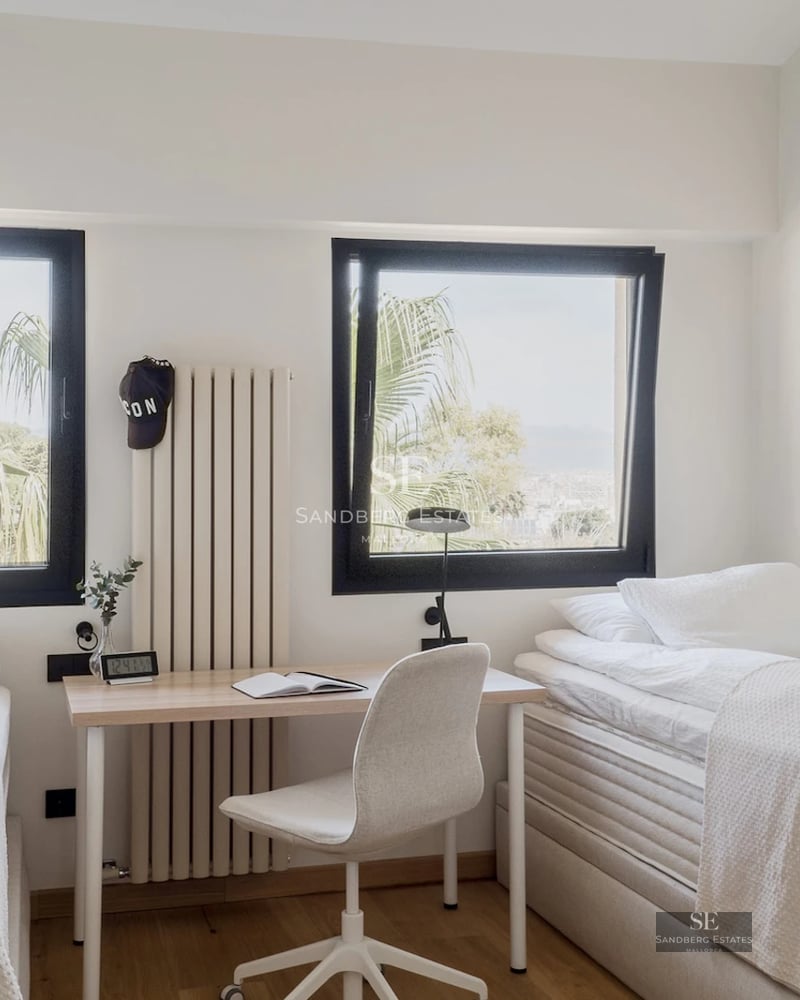 Exterior view of a modern villa featuring an infinity pool, lounge chairs, and lush greenery. Contemporary architecture and panoramic views.