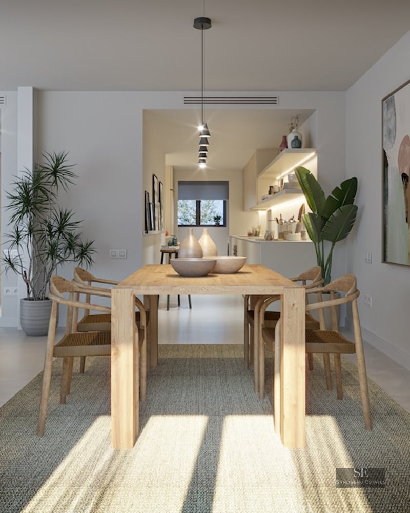 Bright dining area with light wood table, designer chairs, woven rug, and large abstract wall art.