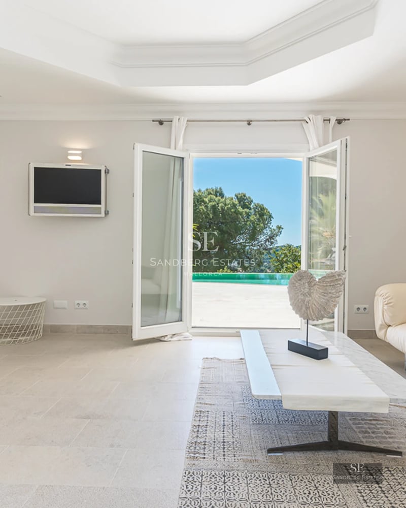 Bright living room with panoramic windows, grey sofas, wooden coffee table, and parquet flooring. Exterior view.