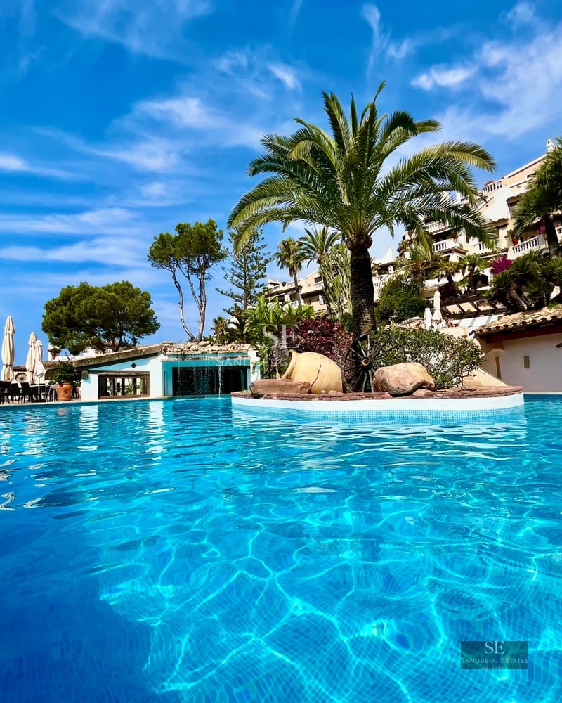 Spacious living room with panoramic windows, modern fireplace, and access to the terrace with pool. Minimalist design and luxurious finishes.