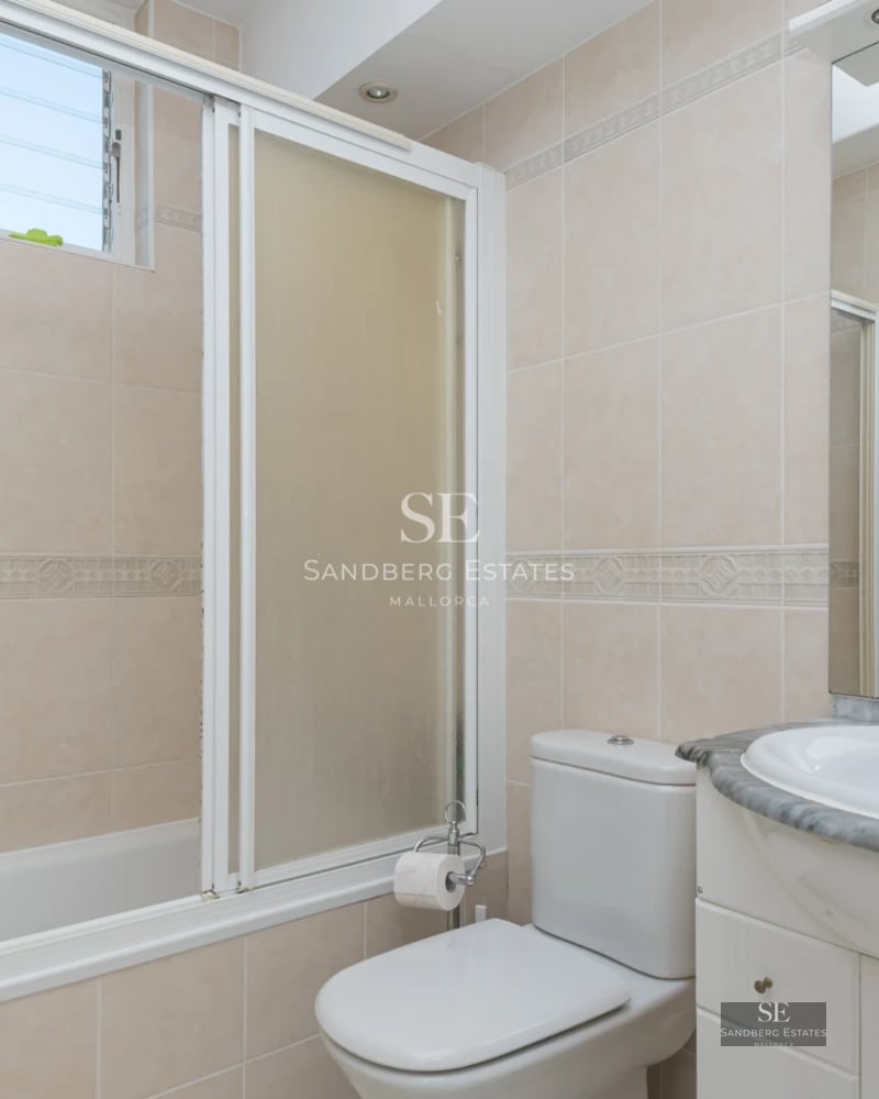 Modern penthouse with glass-enclosed balcony, stunning views, stylish furniture, and abundant natural light.