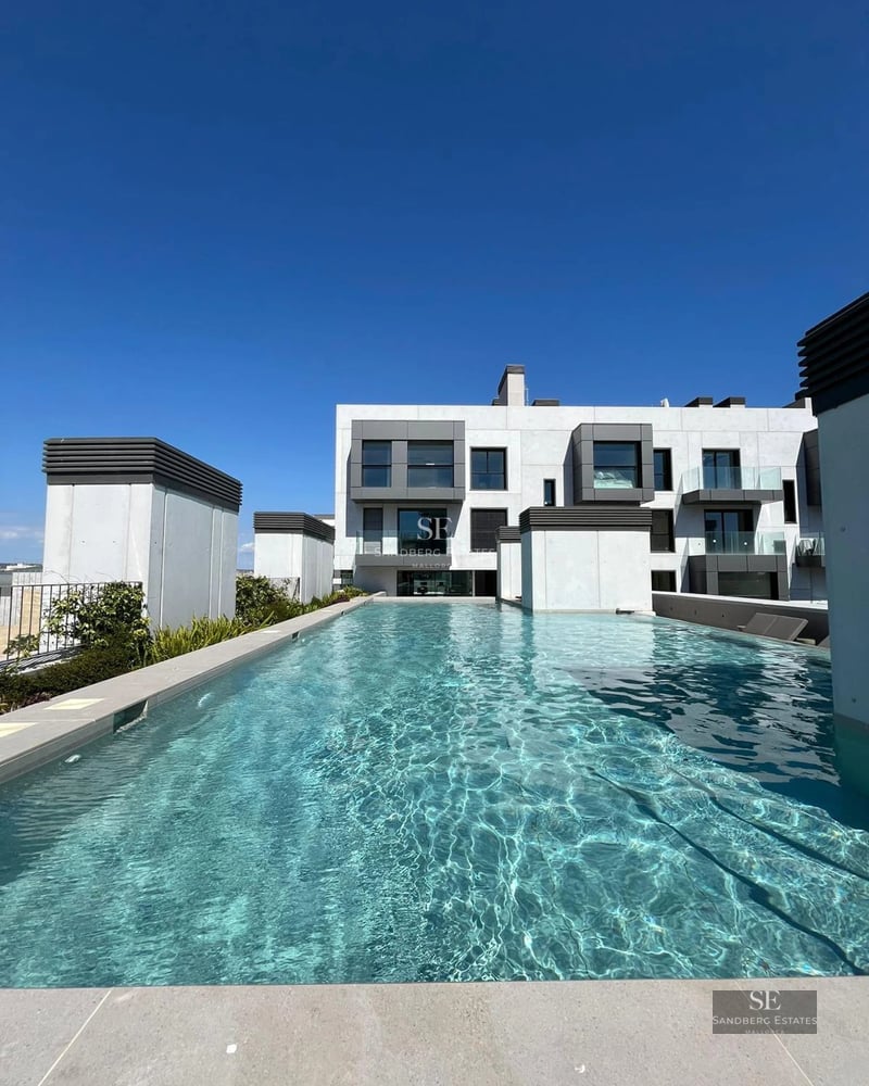 View of luxurious villa with infinity pool, lush garden, and modern architecture. Warm lighting and serene atmosphere.