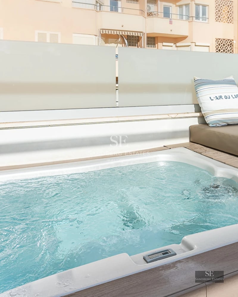 Spacious bright living room with panoramic windows, light wood floors, designer sofas and access to a terrace with panoramic views.