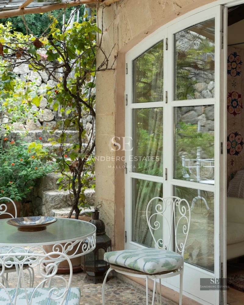 Spacious living room with pool access. Features include large windows, white sofas, and a modern design. Bright and welcoming space.