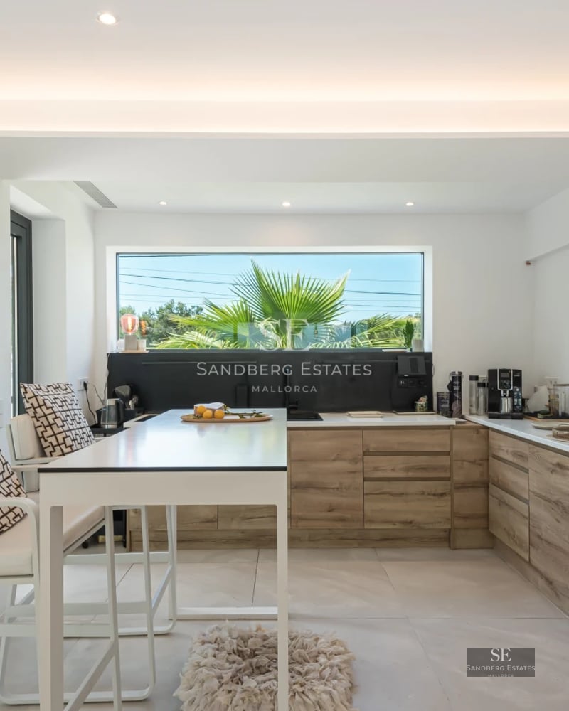 Panoramic view of a modern villa featuring an infinity pool, lush garden, and contemporary architecture. Bright and spacious.