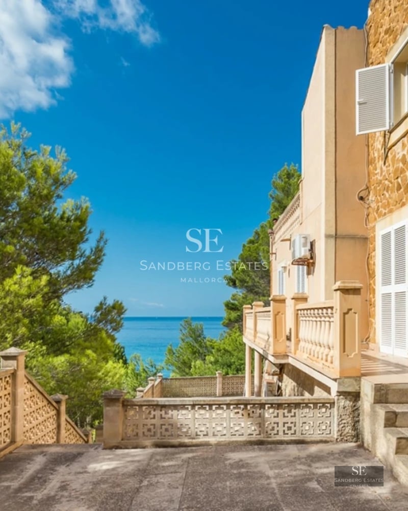 Aerial view of modern villa with infinity pool, lush garden, and minimalist architecture. Wood and stone detailing.