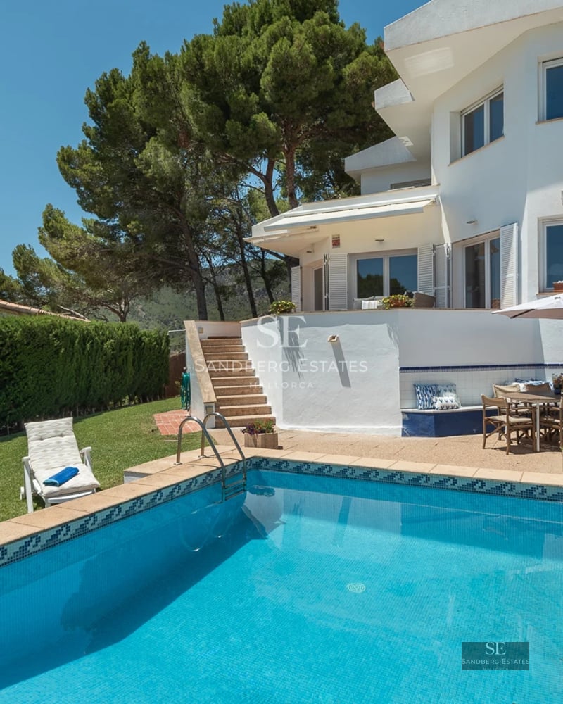 Exterior view of modern villa with reflective pool. Minimalist architecture, large windows, lush gardens. Luxury and comfort.