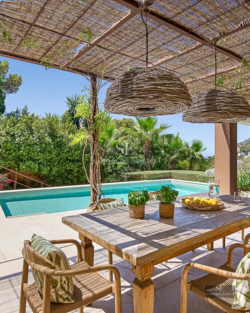 Expansive terrace with infinity pool and panoramic views. Modern, minimalist design with stylish outdoor furniture and lush vegetation.