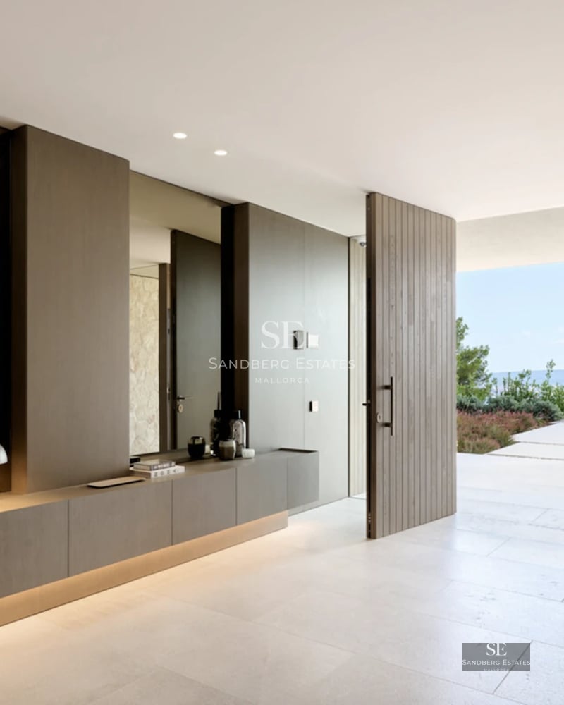 View of an infinity pool with sparkling blue water. Modern architecture, surrounded by lush vegetation. Clear sky.