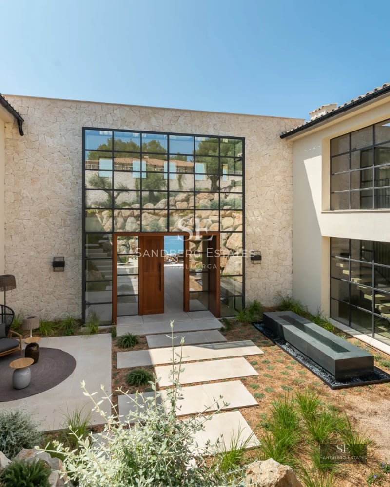 Exterior view of a modern villa with reflecting pool. Minimalist architecture, large windows and lush vegetation.