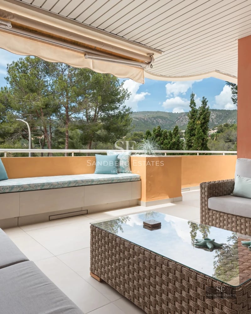 Spacious living room featuring modern fireplace, natural light, beige sofas, and wood flooring. Elegant, welcoming design.