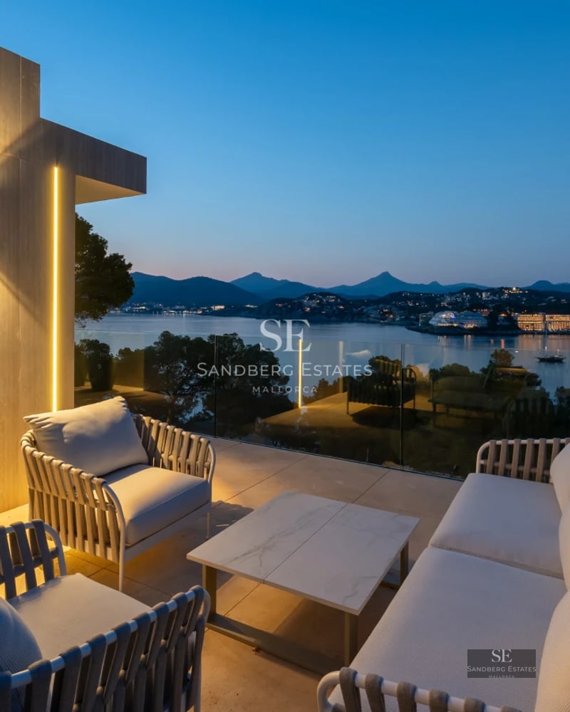 Exterior view of a modern villa featuring an infinity pool, lush garden, and minimalist architecture with large windows.