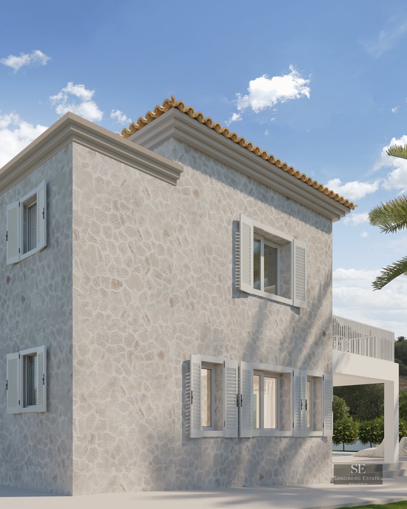 Two-story stone villa with white shutters and terracotta roof next to palm trees under a blue sky.
