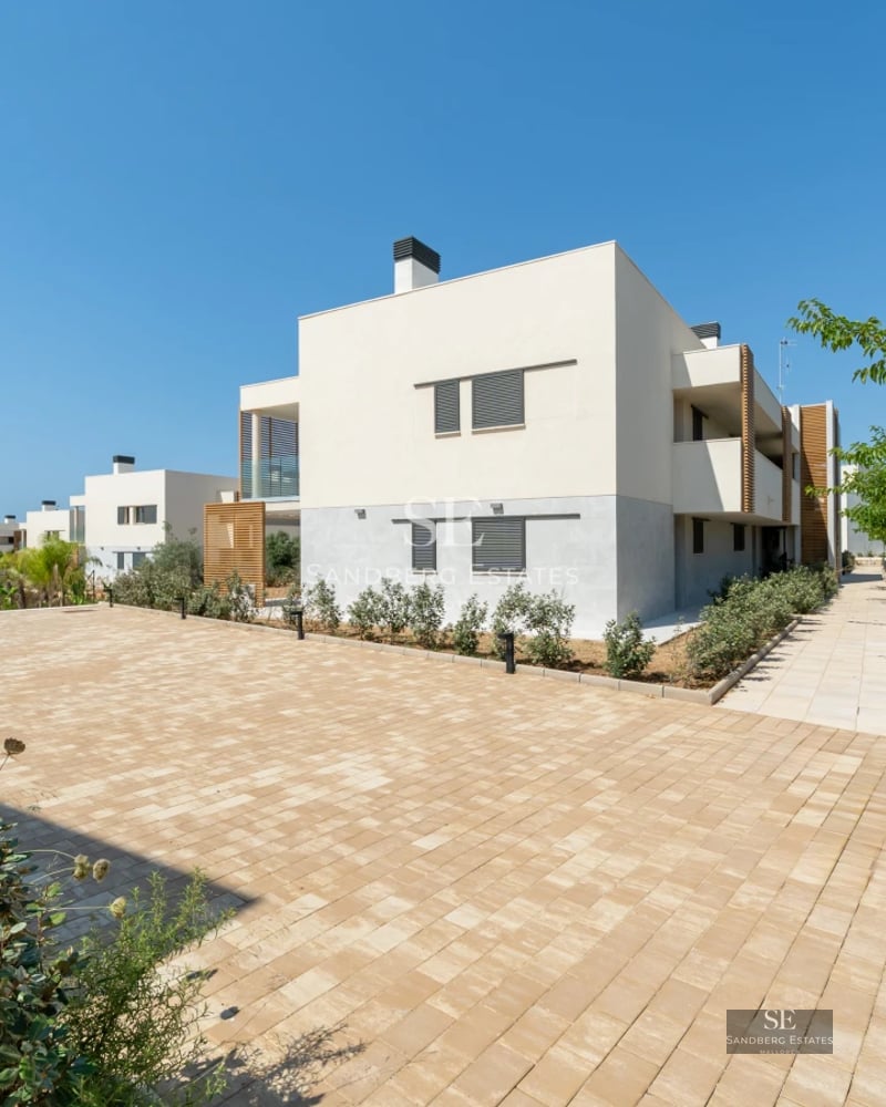Spacious terrace featuring modern furniture, wood flooring, and breathtaking views. Glass railing. Soft lighting and decorative plants.