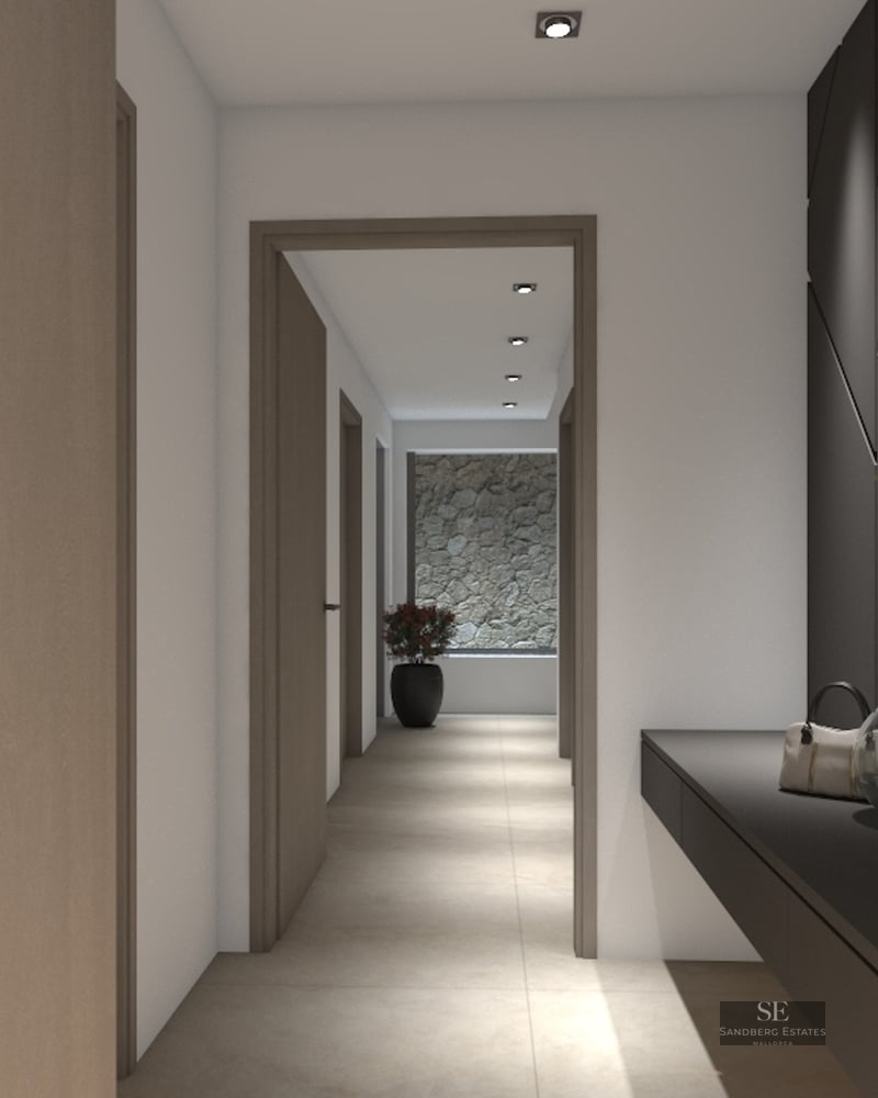 A sleek modern hallway featuring light wood doors, a dark console, a large mirror, and a stone feature wall at the end.