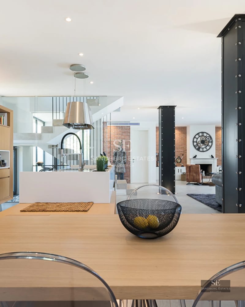 Exterior view of a modern villa with infinity pool, sun loungers, and expansive windows offering panoramic sea views.