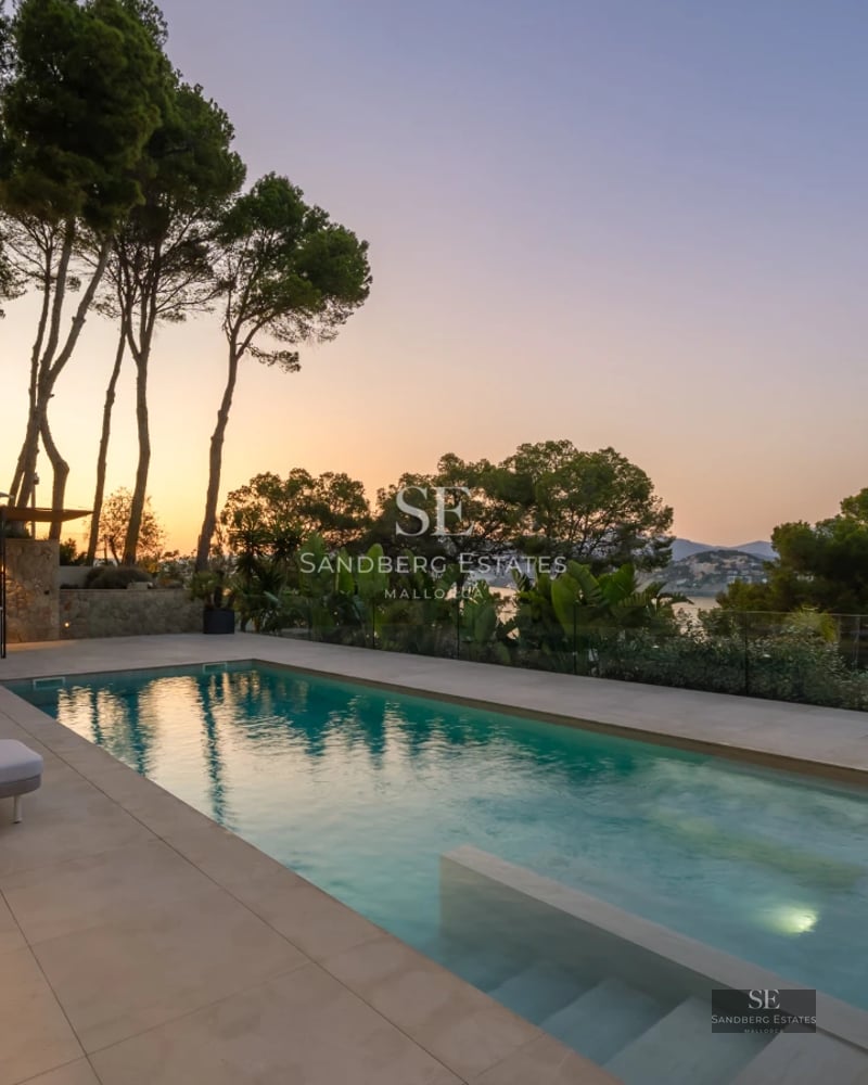 Modern penthouse featuring panoramic windows and a balcony overlooking the sea. Minimalist design and high-end finishes.