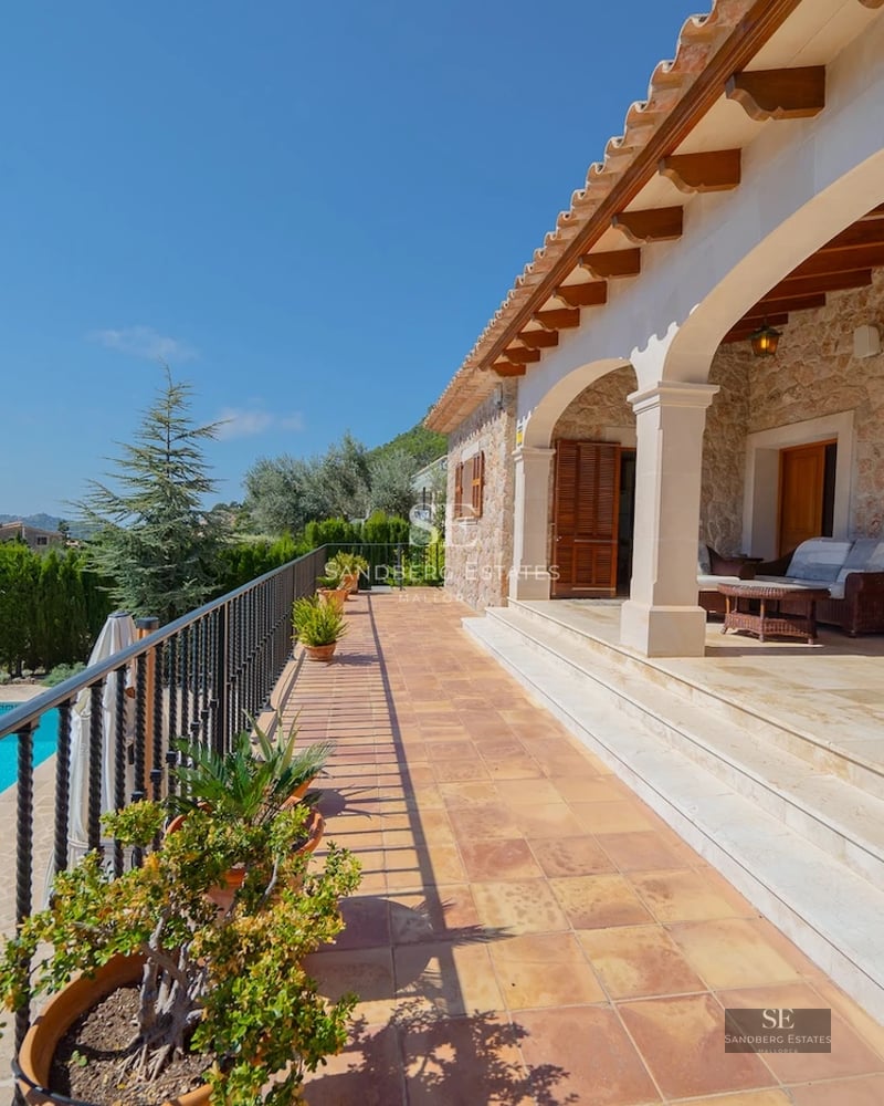 Exterior view of modern villa featuring an infinity pool, lush garden, and expansive terraces. Contemporary architecture, ideal for relaxation.